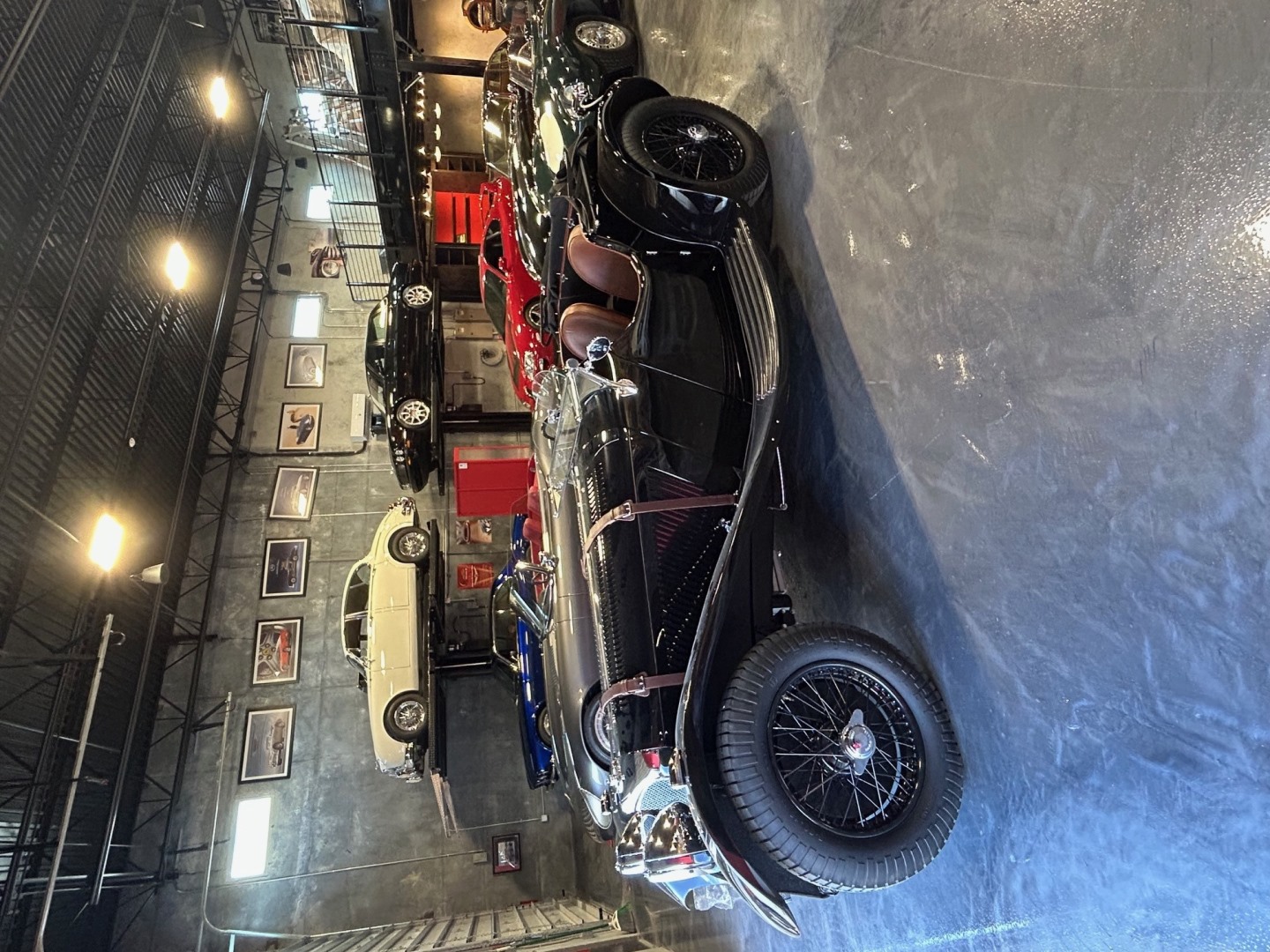 The SS100 parked inside a Florida garage among other classic sports cars, showcasing its timeless design and craftsmanship.